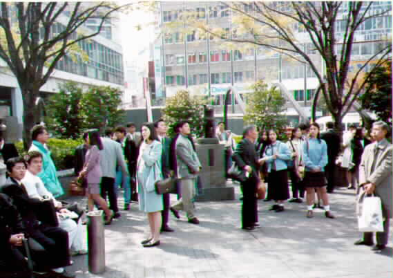 Esta é uma fotografia da estação de Shibuya onde está a estátua de Hachiko. É um marco popular onde os amigos e amantes se encontram.